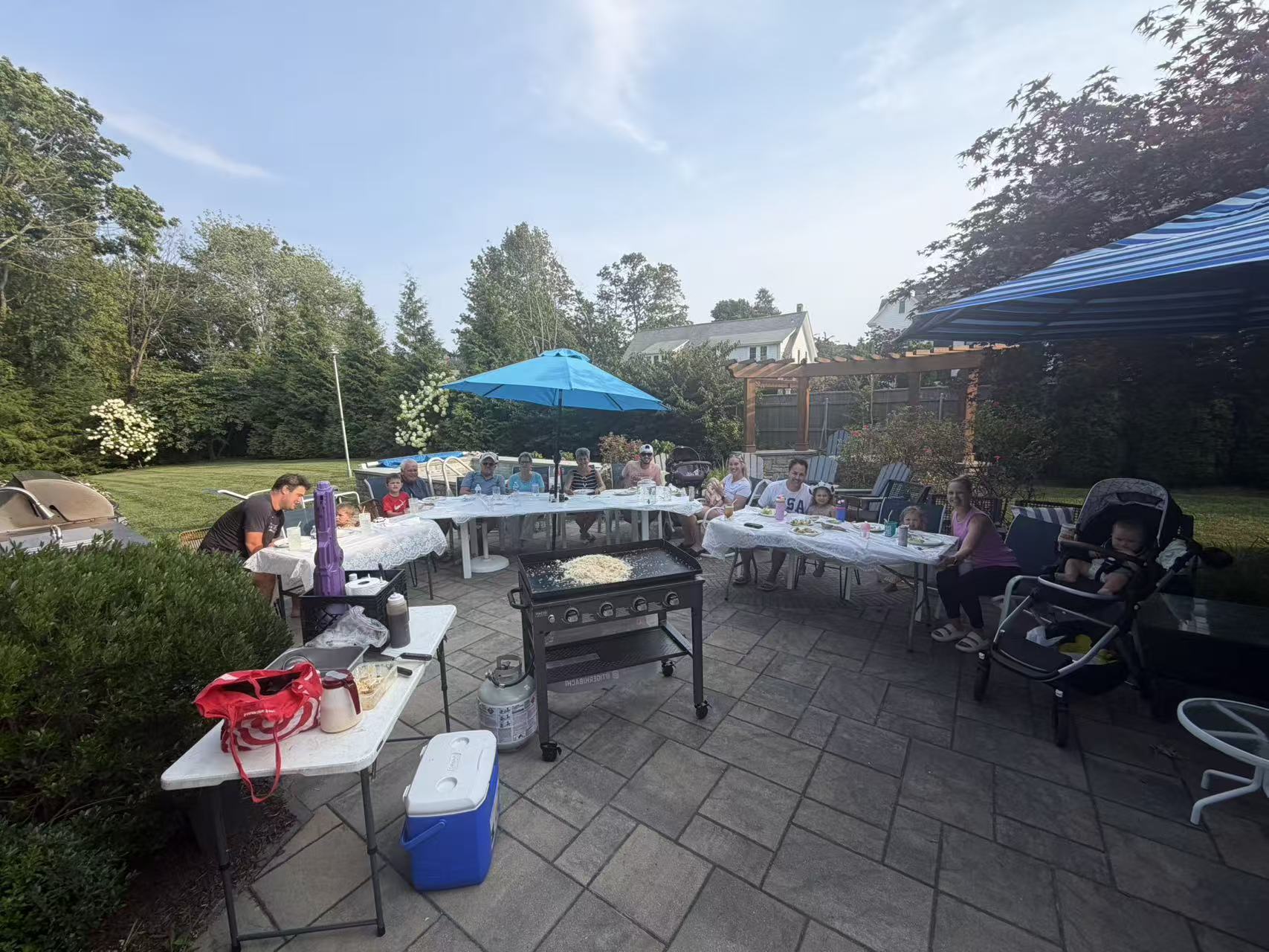 Family backyard hibachi gathering with the Blackstone grill smoking