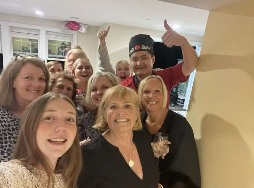Guests posing for a group photo with their Go For Hibachi chef