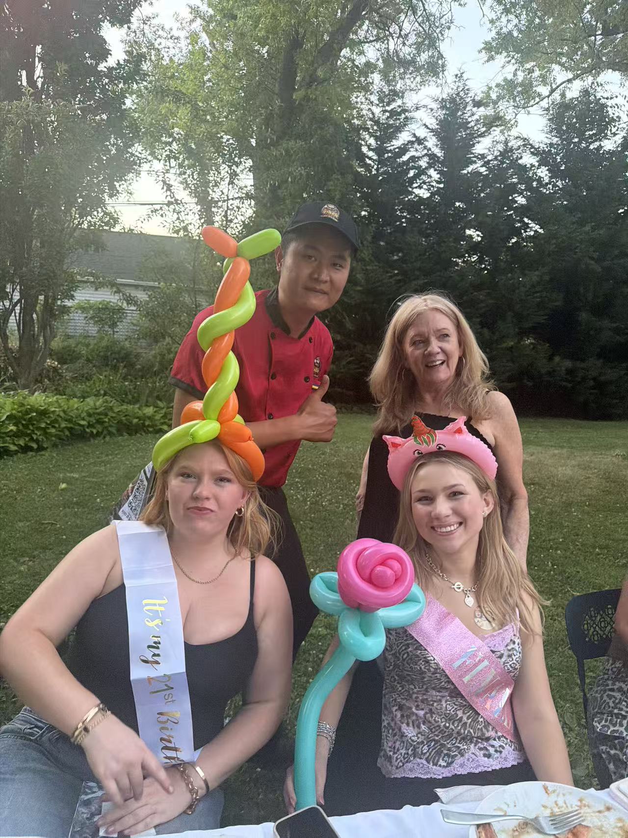 Birthday guests wearing balloon hats made by a Go For Hibachi chef