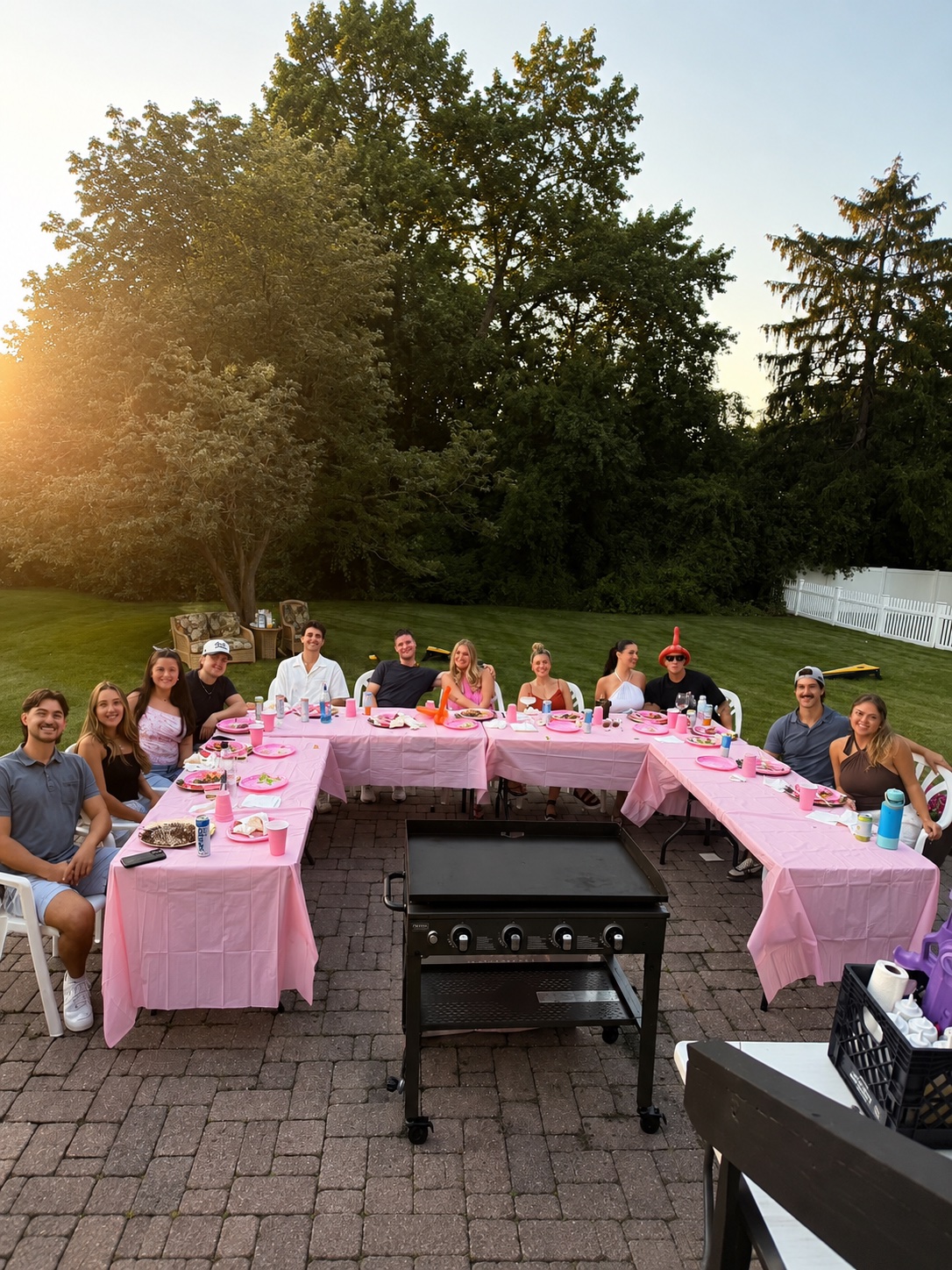 Large group of guests seated at a pink-themed backyard hibachi party hosted by Go For Hibachi